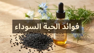 صورة غلاف تُظهر حبات الحبة السوداء (حبة البركة) متناثرة على سطح خشبي مع زجاجة زيت ذهبية وأزهار نبات حبة البركة الخضراء