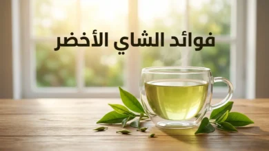 كوب زجاجي أنيق من الشاي الأخضر على طاولة خشبية محاط بأوراق شاي طازجة مع إضاءة صباحية طبيعية وعنوان فوائد الشاي الأخضر