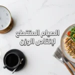صورة غلاف لمقال الصيام المتقطع لإنقاص الوزن تُظهر طبق طعام صحي متوازن بجانب ساعة وكوب ماء بالليمون وقهوة سوداء على سطح رخامي فاتح مع إضاءة طبيعية