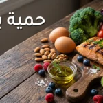 صورة غلاف لمقال حمية باليو تعرض أطعمة طبيعية كالسلمون المشوي والأفوكادو والمكسرات والخضروات الطازجة على طاولة خشبية مع عنوان حمية باليو