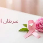 شريط وردي رمز الوعي بسرطان الثدي مع زهرة طازجة على خلفية بيضاء نظيفة