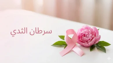 شريط وردي رمز الوعي بسرطان الثدي مع زهرة طازجة على خلفية بيضاء نظيفة