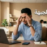 رجل شاب يضغط بيديه على جبهته بسبب صداع الجبهة أثناء العمل المكتبي مع عبارة صداع الجبهة على الصورة