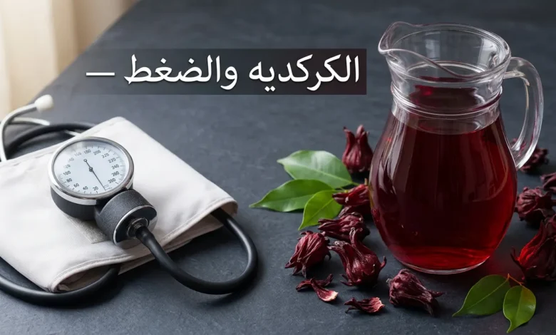 إبريق زجاجي مليء بمشروب الكركديه الأحمر بجانب جهاز قياس ضغط الدم على سطح داكن