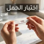 يدان تمسكان شريط اختبار حمل منزلي يُظهر خطين وردييَن على خلفية رخام أبيض في إضاءة صباحية طبيعية