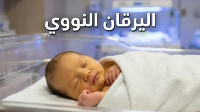 مولود حديث الولادة يظهر على بشرته اصفرار خفيف في بيئة مستشفى هادئة مع إضاءة علاجية زرقاء في الخلفية