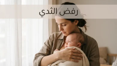 أم تحمل رضيعها بحنان بينما يبتعد قليلاً عن الثدي في مشهد هادئ ودافئ