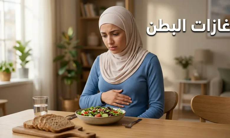 صورة غلاف لمقال طبي عن غازات البطن تُظهر امرأة شابة تضع يدها على بطنها بجانب وجبة صحية على طاولة طعام