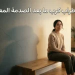 صورة غلاف مقال اضطراب كرب ما بعد الصدمة المعقد تظهر امرأة في مكان هادئ مع إضاءة طبيعية دافئة وجدار يتدرج من الظلمة إلى النور رمزاً للتعافي