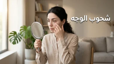 امرأة شابة تفحص لون ملتحمة عينها أمام المرآة للكشف عن شحوب الوجه