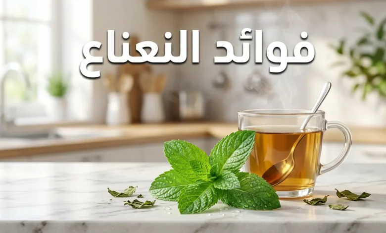 أوراق نعناع فلفلي طازجة مع كوب شاي نعناع ساخن على سطح رخامي أبيض وعنوان فوائد النعناع