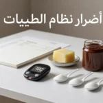 صورة غلاف واقعية تُظهر جهاز قياس سكر مع ملاعق سكر وزبدة وعبوة دهن كاكاو وبندق بلا علامة تجارية للتعبير عن أضرار نظام الطيبات.
