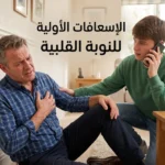 صورة غلاف توضيحية تظهر شخصاً يعاني من ألم في الصدر وبجانبه شخص آخر يقدم الإسعافات الأولية للنوبة القلبية ويتصل بالإسعاف مع وجود أسبرين على طاولة قريبة