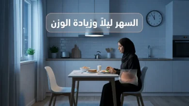 امرأة عربية تسهر ليلاً في مطبخ حديث مع وجبة متأخرة وإشارة بصرية صحية عن ارتباط السهر ليلاً وزيادة الوزن