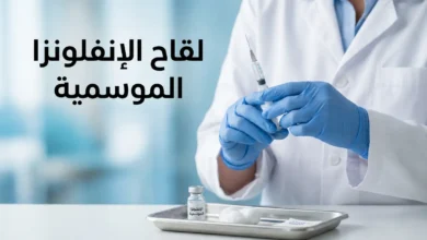 صورة غلاف تُظهر يد متخصص رعاية صحية يرتدي قفازات طبية زرقاء يحمل حقنة لقاح الإنفلونزا الموسمية بجانب قارورة اللقاح على صينية طبية في عيادة حديثة
