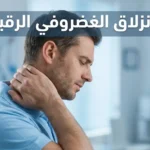 رجل في أواخر الثلاثينيات يمسك رقبته من الجانب الأيسر بتعبير ألم خفيف داخل عيادة علاج طبيعي حديثة مع عنوان الانزلاق الغضروفي الرقبي
