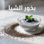 بذور الشيا مع بودينغ الشيا المنقوع في وعاء زجاجي على سطح رخامي أبيض مع التوت الأزرق وأوراق النعناع