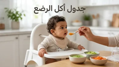 رضيع يجلس بأمان في كرسي الطعام بينما تُقدَّم له ملعقة من المهروس مع ظهور عبارة جدول أكل الرضع على الغلاف.