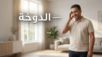 رجل يُمسك رأسه بيده بسبب الدوخة في منزل مضاء بشكل طبيعي