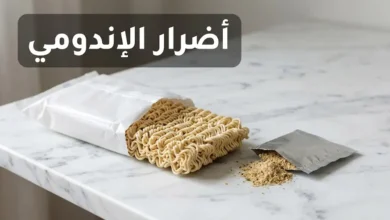 عبوة نودلز سريعة التحضير مفتوحة مع كيس التوابل على سطح رخامي أبيض